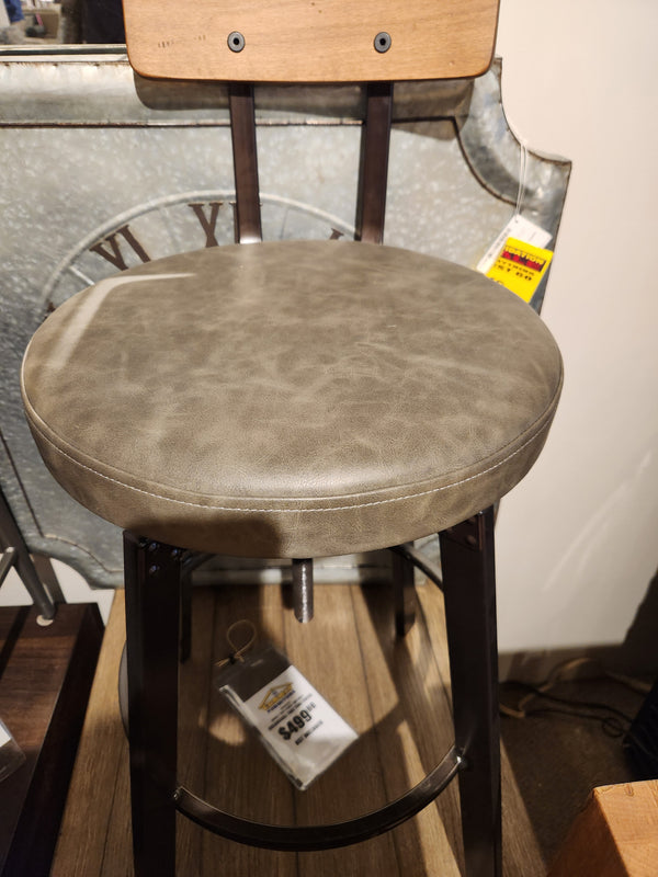 The Amisco Architect Counter Height Stool features a round gray padded seat, wooden back, and metal frame with price tags.