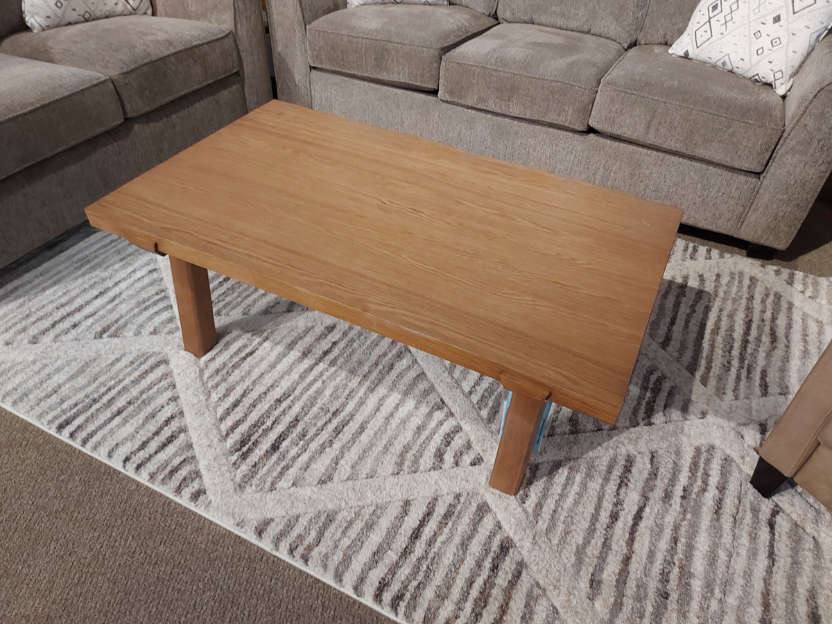 A Magnussen T5570 Lindon Rectangle Cocktail Table sits between two gray sofas on a patterned rug.