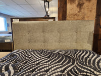 Featuring the Julien Beaudoin Queen Heaven Upholstered Bedframe with a tufted headboard and stylish black-and-white blanket.