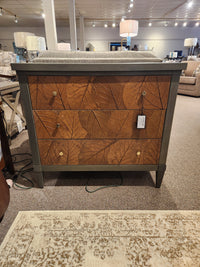 The Crestview Collection Arbor Three Drawer Chest in sage green with leaf pattern is displayed in the showroom.