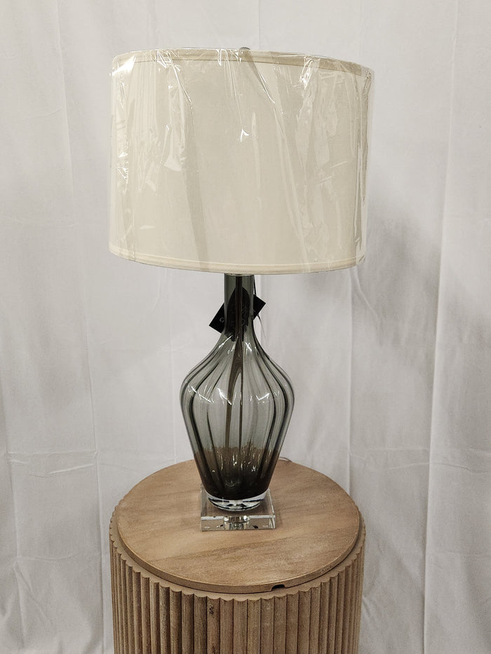 The Pacific Coast 790A4 Nile Glass Table Lamp features a smoky gray vase silhouette and cream shade on wood stand.