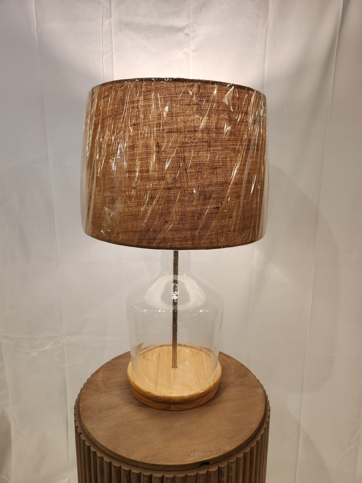 The Pacific Coast 37M69 Taylor Table Lamp features a fillable glass base and brown fabric shade, ideal for coastal homes.