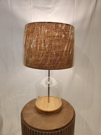 The Pacific Coast 37M69 Taylor Table Lamp features a fillable glass base and brown fabric shade, ideal for coastal homes.