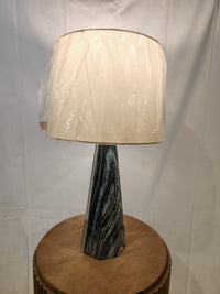The Pacific Coast Bluestone set of 2 table lamps with linen drum shades sits on a round wooden table.