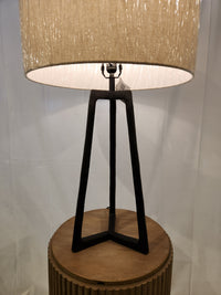 Ashley Ryandale Table Lamp with beige shade, antiqued black cast aluminum base, on a wood side table.