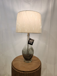 Pacific Coast Sparrow set of 2 table lamps with smoke gray finish and white shade on a round wooden stand.