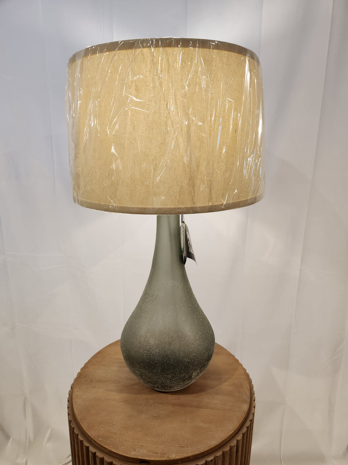 The Pacific Coast 87-7776-78 City Shadow Table Lamp has blue grey textured glass and a beige shade for stylish lighting.
