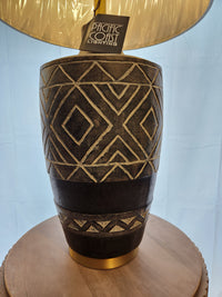 73M52 Mesa Table Lamp by Pacific Coast with ethnic patterns sits on a round wooden surface.