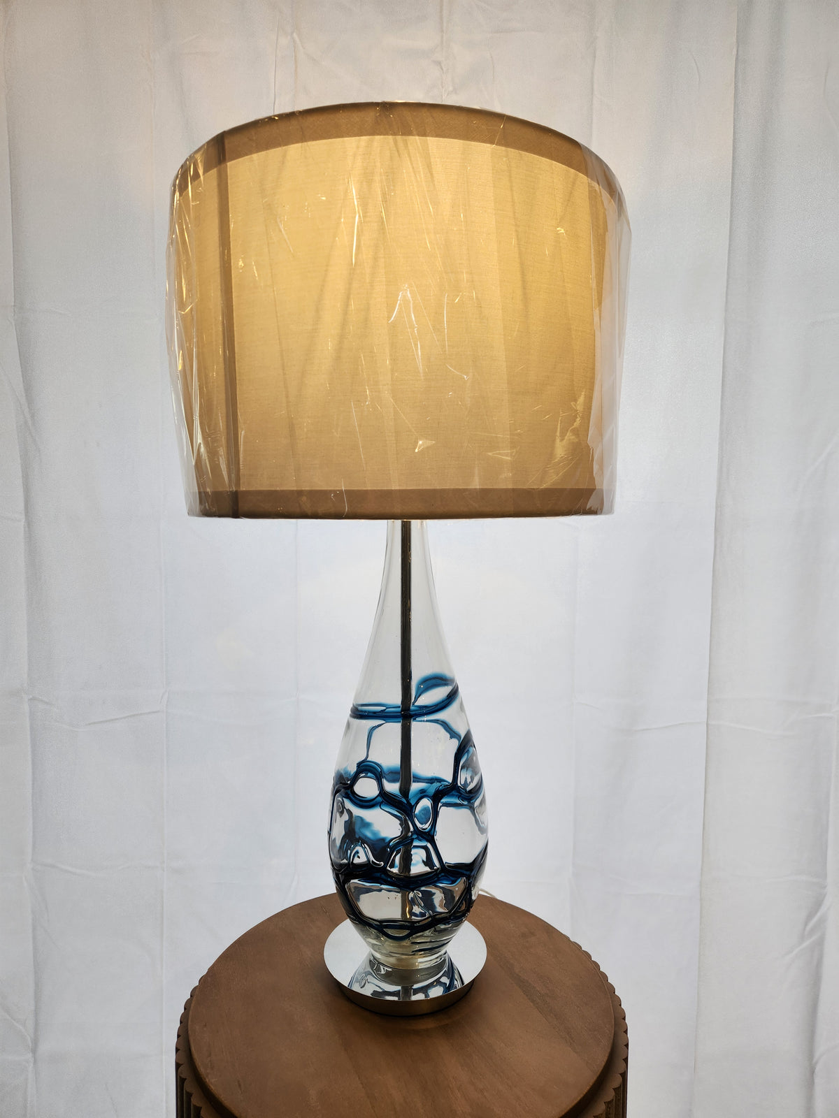 The Pacific Coast 87-6910-23 Indigo Blue Table Lamp with beige shade adds a modern touch to your space.