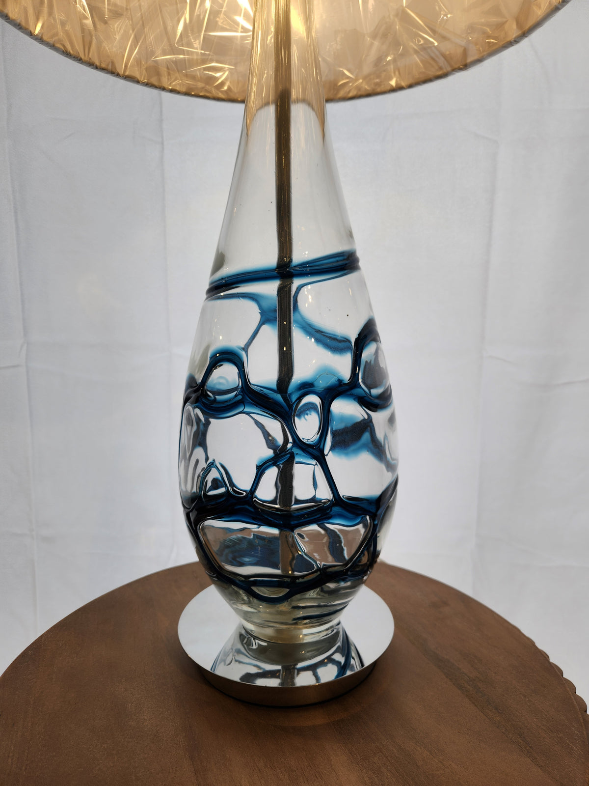 The Pacific Coast 87-6910-23 Indigo Blue Table Lamp adds a modern touch and soft glow with its blue glass swirls.