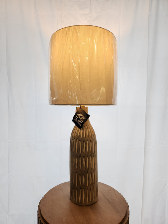 The 73E50 Stonewall Table Lamp by Pacific Coast features a hand-carved base and wrapped shade for a refined look.