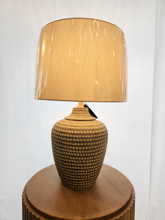 The Pacific Coast 767H1 Alese Table Lamp adds modern sophistication with its textured ceramic base on a round table.
