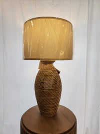 A Pacific Coast 90V98 Finley Table Lamp with linen shade sits on a round wooden pedestal against a white backdrop.