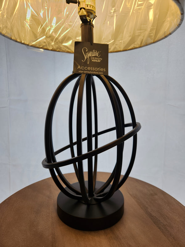The Ashley L204164 Manasa black metal spherical table lamp base features an armillary design and wood accent.