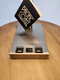 The Pacific Coast 902c0 Elton Table Lamp has a rectangular brushed nickel base with USB ports and power switch.