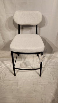 The Amisco Orly Counter Height Bar Stool features a light gray cushioned seat, backrest, and black metal legs on white.