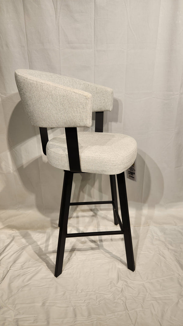 The Amisco Grissom Stool, gray upholstered with a low backrest and black metal legs, is set against a white backdrop.