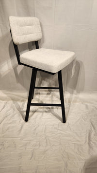 Amisco's Phoebe Counter Height Swivel Bar Stool in light gray features black legs and backrest on a light fabric.