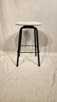 The Amisco Button Counter Height Swivel Stool features a light round seat and black metal legs on a plain white backdrop.