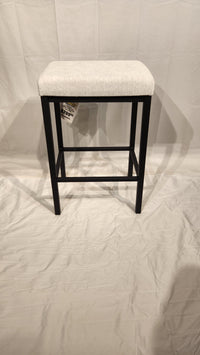 The Bradley Counter Height Bar Stool by Amisco features a light seat and black metal legs on a white fabric background.