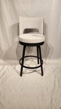 The Amisco Brock Counter Height Swivel Bar Stool features a light gray padded seat, black frame, and circular footrest.