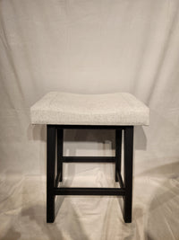 The Amisco Miller Counter Height Bar Stool features a light gray cushioned seat and black wooden legs.