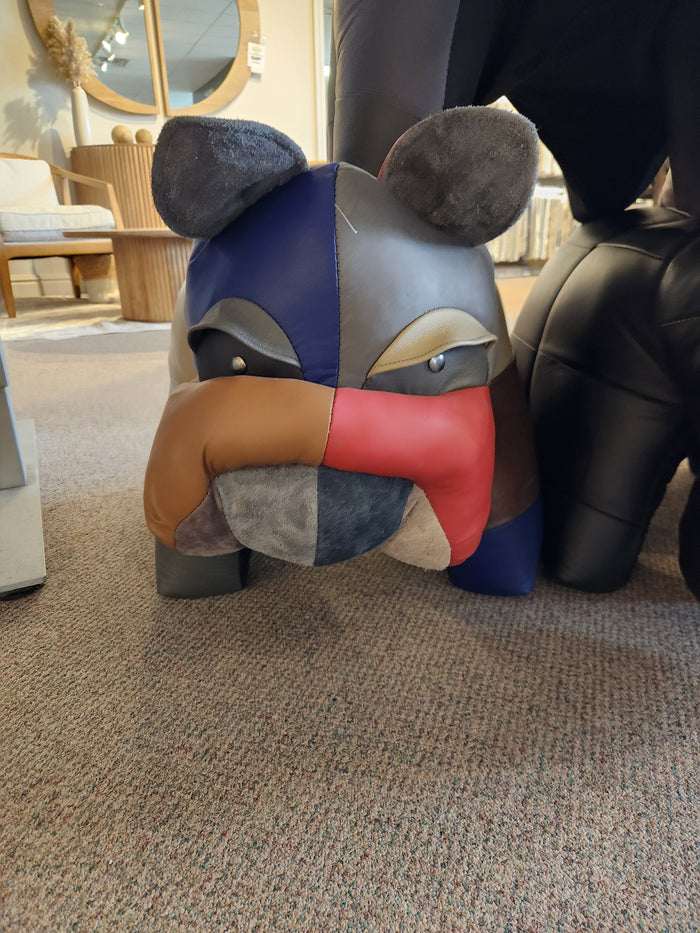 Reiner's Originals bulldog ottoman with patchwork design decorates a carpeted furniture store floor.