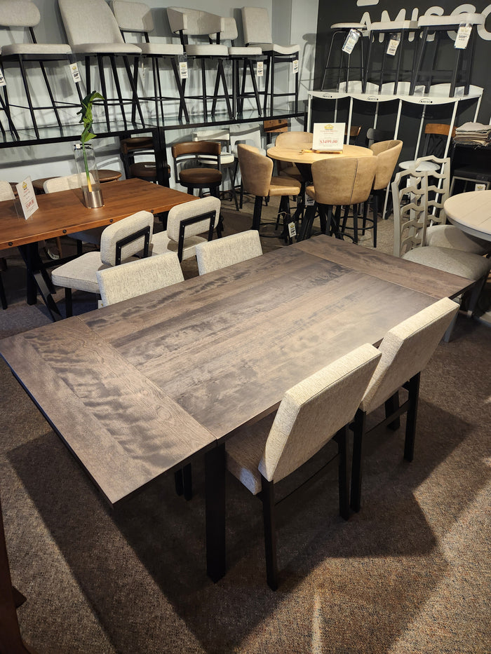 Modern dining room with Lewis 36"x48" wood table package by Amisco and six beige upholstered chairs in a store setting.