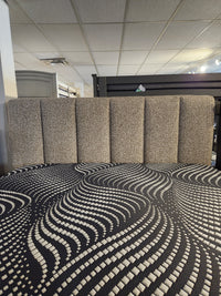 Palliser's Verttia 77140 King Bed, power-adjustable with a textured headboard, black and white bedspread, in grid-ceiling room.