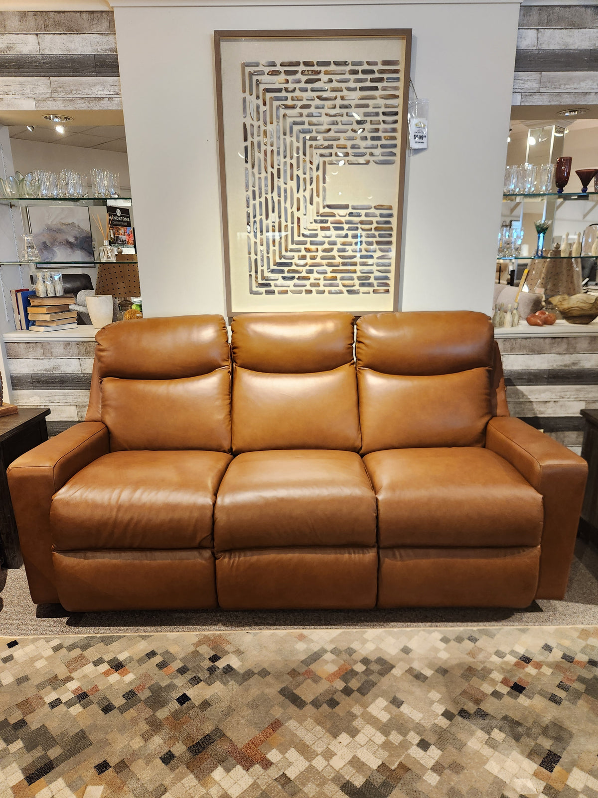 Tailored look: La-z-boy's 781 Emmons reclining brown leather sofa with art above and a patterned rug in front.