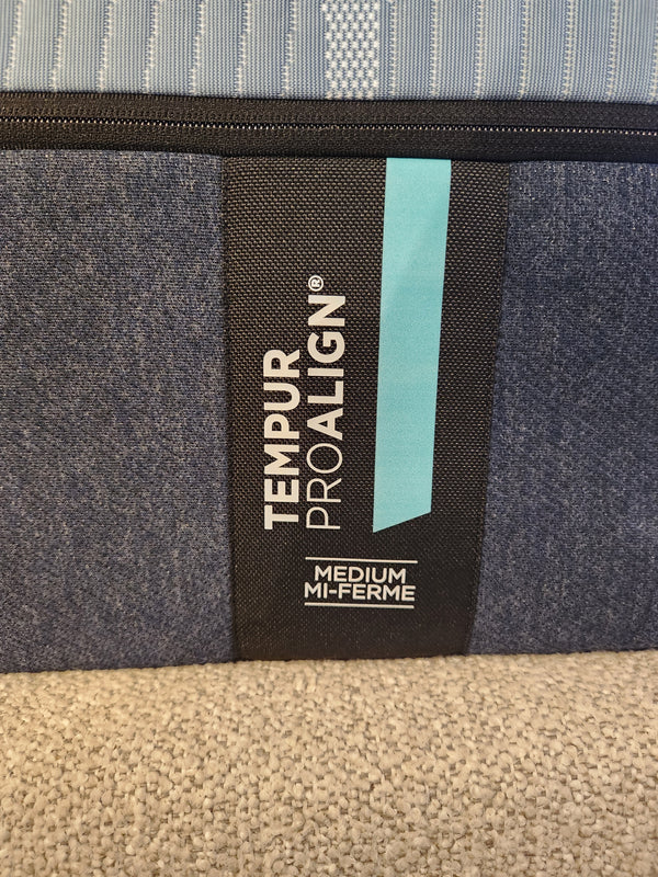 Close-up of a Pro Align 2.0 - Medium label by Tempur-pedic, with blue/black fabric and TEMPUR-APR+ for pressure relief.