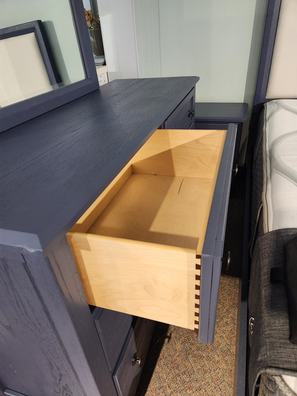 The Vaughan Bassett Artisan & Post dresser in White Oak has a drawer open, showing its light wood interior.