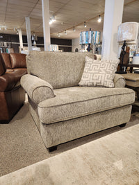 The showroom floor features the 2285 Chair and a Half by Decor-rest, a spacious gray armchair with a patterned pillow and solid wood construction.
