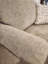 Close-up of the 2285 Chair and a Half from Decor-rest, featuring a textured gray finish with an armrest and a patterned cushion, highlighting its solid wood construction. The fabric boasts a subtle swirl design, providing both style and comfort. Proudly Canadian made for ensuring durability and timeless elegance.