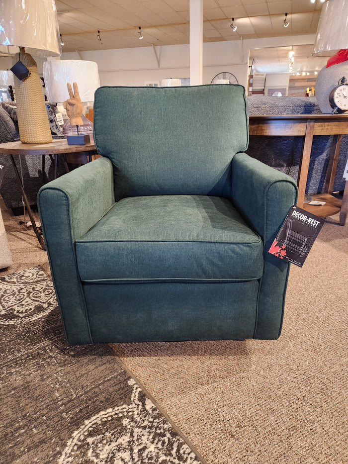 The 2284 Swivel Accent Chair by Decor-rest, featuring a green upholstery and optimal support with a rectangular backrest, is displayed on a carpeted floor in a furniture store.