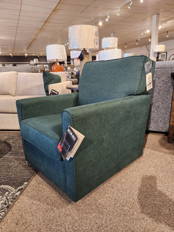 The Decor-rest 2284 Swivel Accent Chair is elegantly showcased in the furniture store showroom, complete with price tags. Its swivel glider design provides optimal support and adds a touch of modern style to any space.