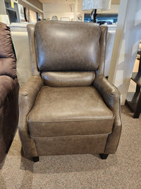 The Leather Craft 749 Chair, a brown leather accent with high back and cushioned seat, is showcased in the store.