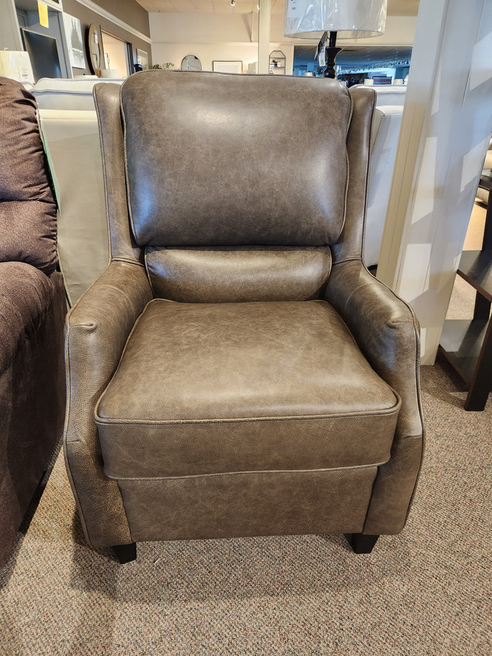 The Leather Craft 749 Chair, a brown leather accent with high back and cushioned seat, is showcased in the store.
