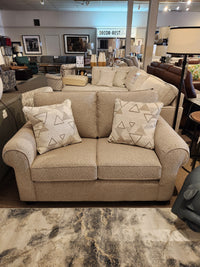 Decor-rest 2179 Loveseat, with elegant upholstery and two patterned cushions, featured in a furniture store showroom.