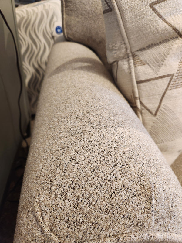 Close-up of a light gray Decor-rest 2179 Loveseat armrest with a patterned cushion and wavy decor in the background.