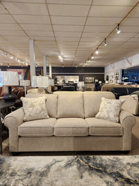 2179 Queen sofabed by Decor-rest with patterned cushions, surrounded by furnishings in a stylish furniture store.