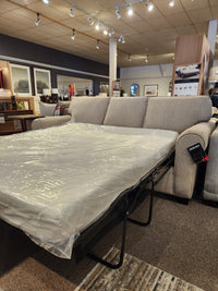 Canadian-made Decor-rest 2179 Queen Sofabed with memory gel foam mattress, partially extended, surrounded by decor and lighting.