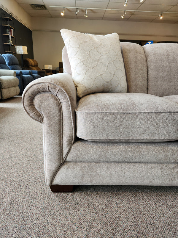 Close-up of a La-Z-Boy 435 Mackenzie Queen Sofa Bed with ComfortCore® cushions and rolled arms on a carpeted showroom floor.