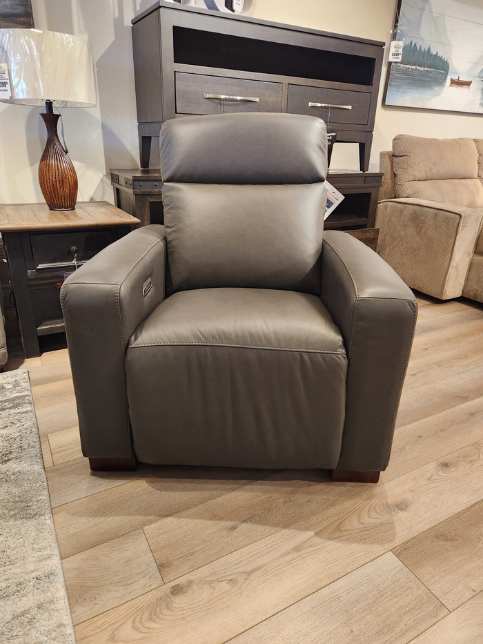 The La-Z-Boy 811 Acadia gray leather power recliner sits on a wooden showroom floor, surrounded by other furniture.