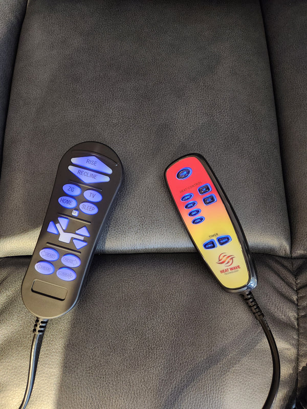 Two remotes rest on the Rhea PL442M MED Power Lift Chair's black leather: one adjusts the chair, the other for HeatWave settings.