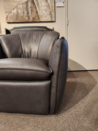 A black Leather Craft 752 Swivel Chair on a carpeted floor, beneath a painting and thermostat in a Toronto room.