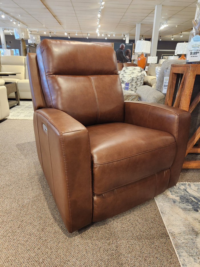 A Muskoka Power Reclining Chair by Aurora Furniture with moccasin stitching shown in a furniture store setting.