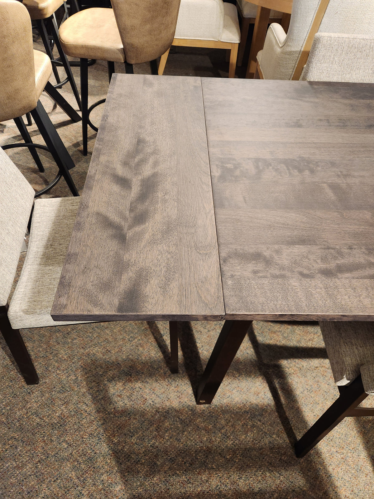 Amisco's Alex 36"x60" dining set features a solid top with cushioned chairs, ideal for carpeted rooms.