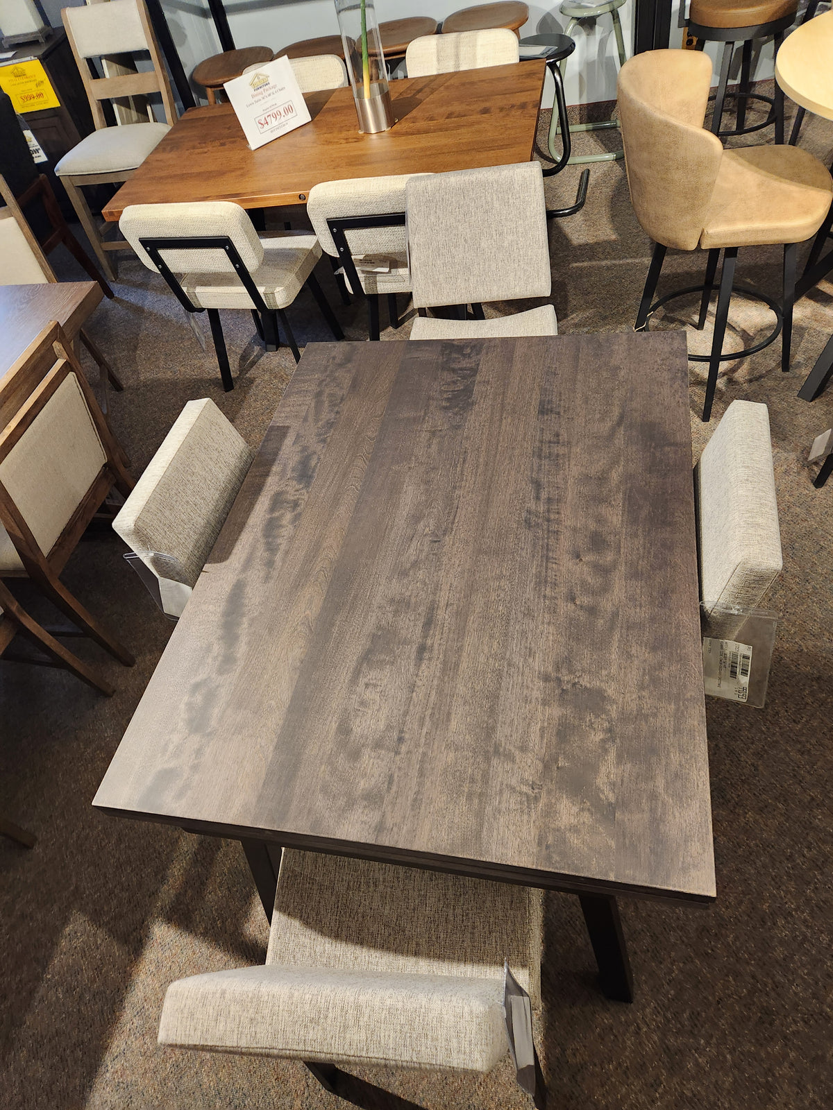 Amisco's Alex 36"x 60" dining set includes a scratch-resistant table and four upholstered chairs in a furniture store display.