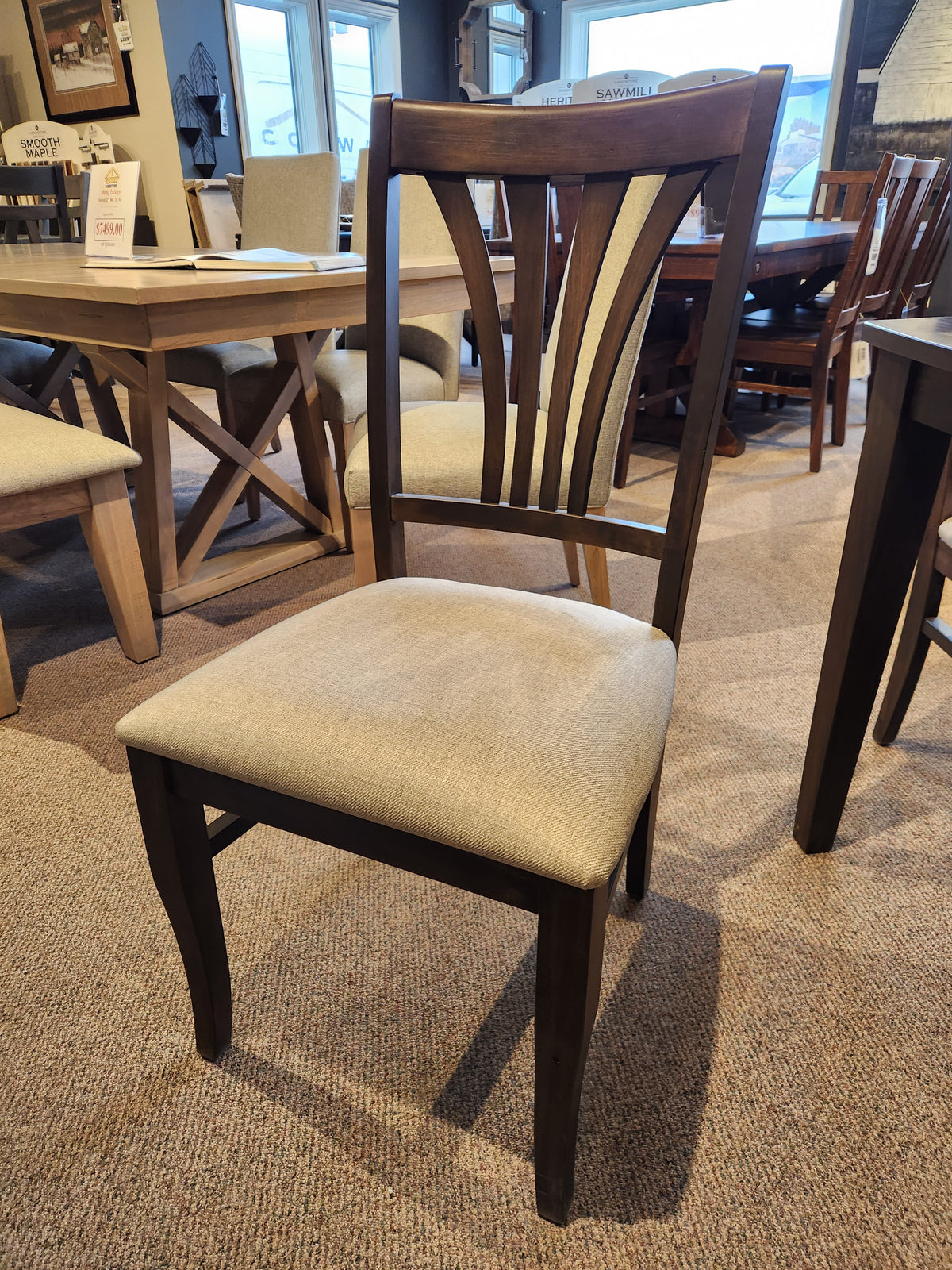 Handstone's Parker dining package includes rustic aesthetic chairs with beige cushions and curved slat backrests in a showroom.